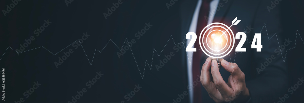 Businessman hand holds light bulb with target and number new year2024, innovative idea of ​​inspirat