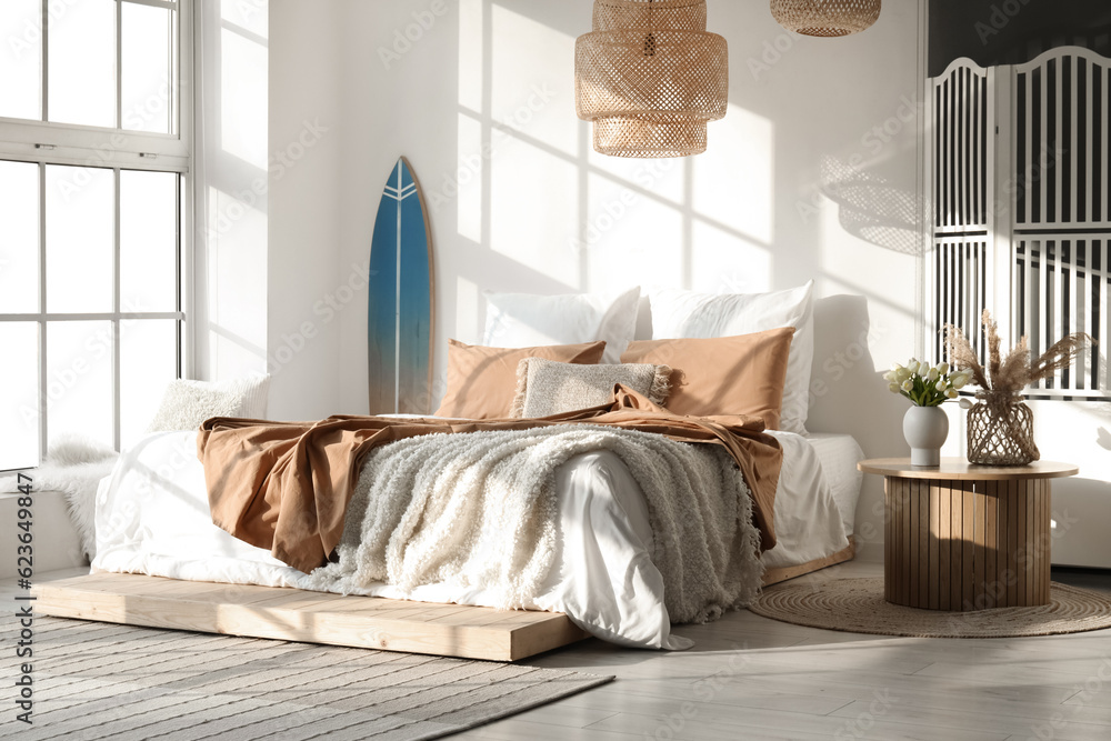 Interior of modern bedroom with surfboard and folding screen