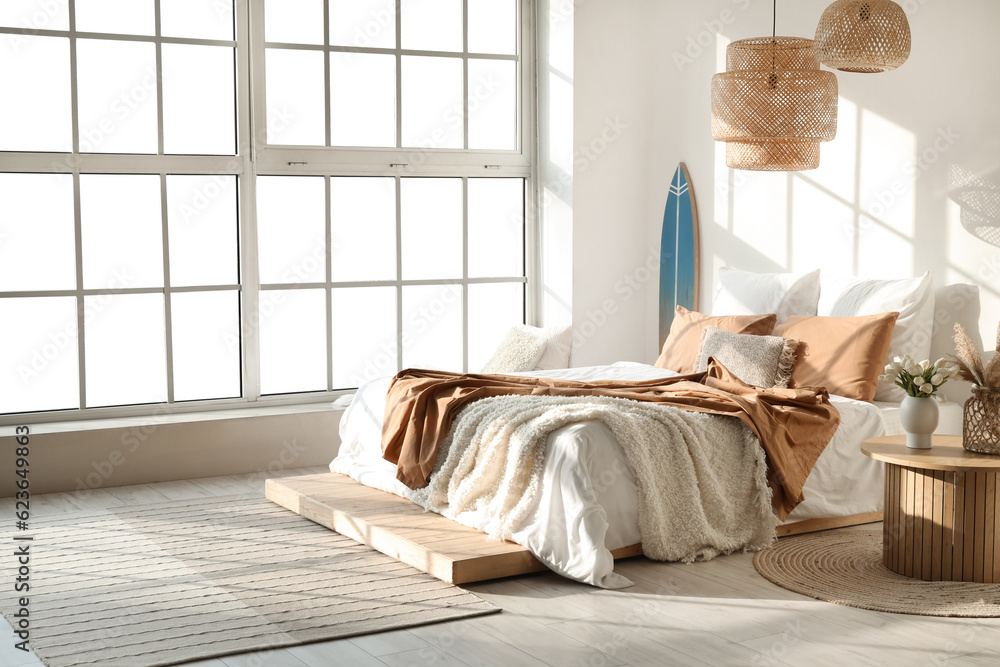 Interior of modern bedroom with surfboard and big bed