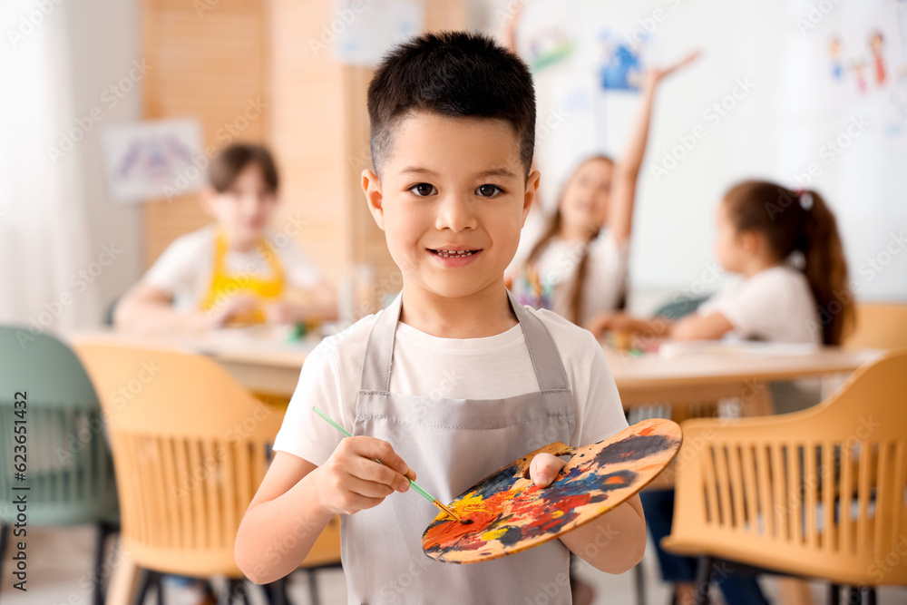 Cute little boy with paint palette in art class