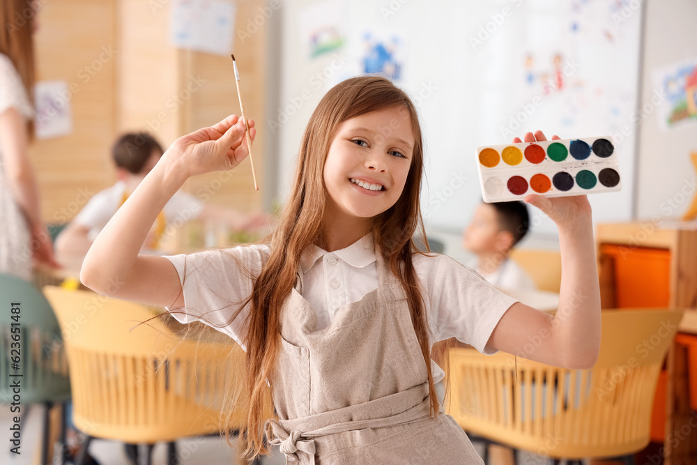 Little girl with paints in art class