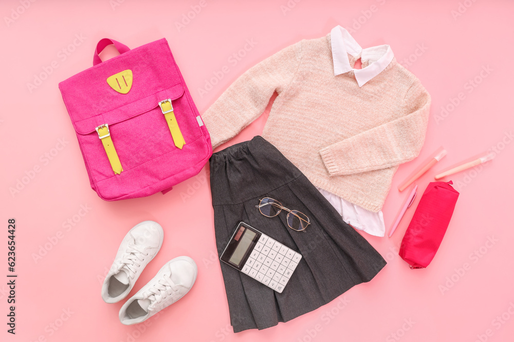 Composition with stylish school uniform, backpack, eyeglasses and stationery on pink background