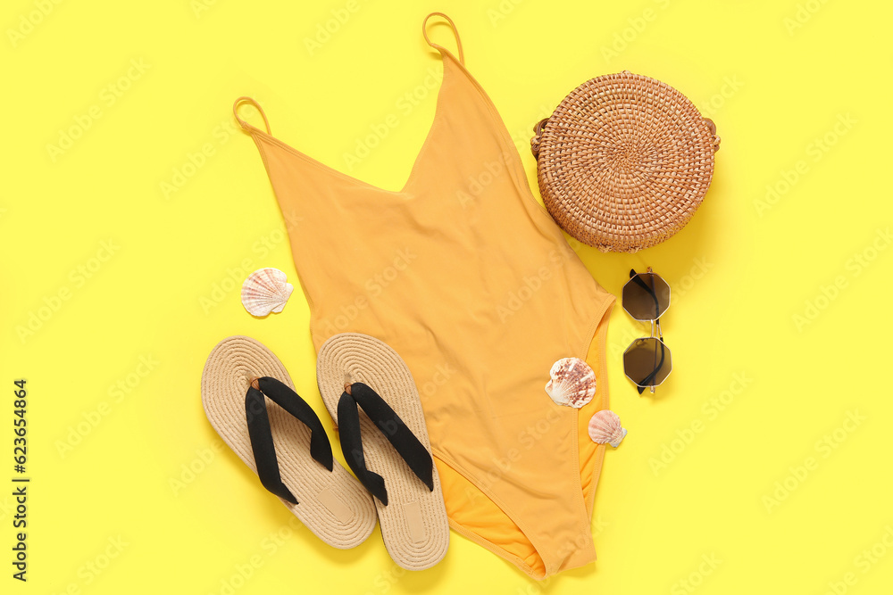 Stylish swimsuit, bag, sunglasses, flip-flops and seashells on color background