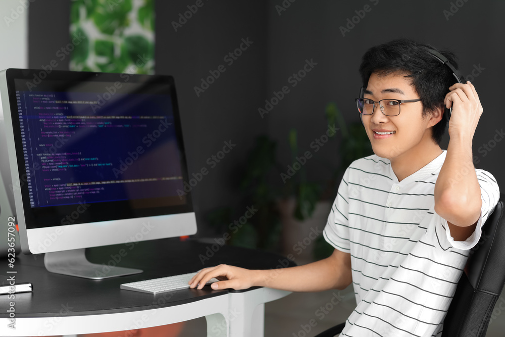 Male Asian programmer working with computer in office