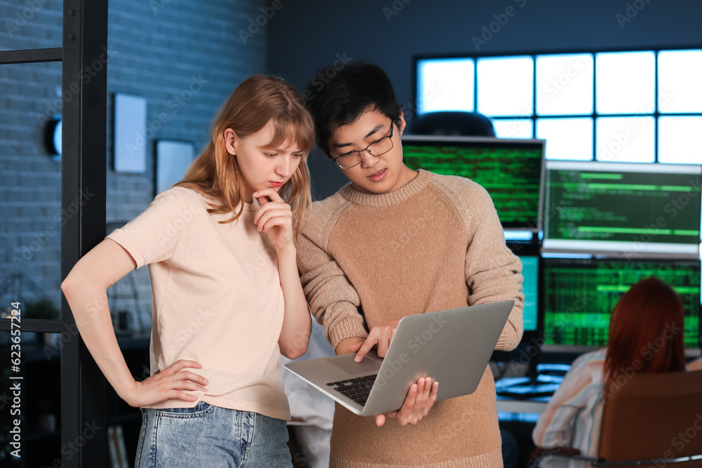 Young programmers working with laptop in office