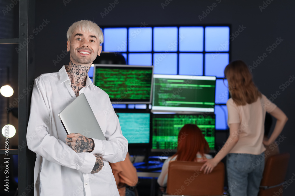 Male programmer with laptop in office at night