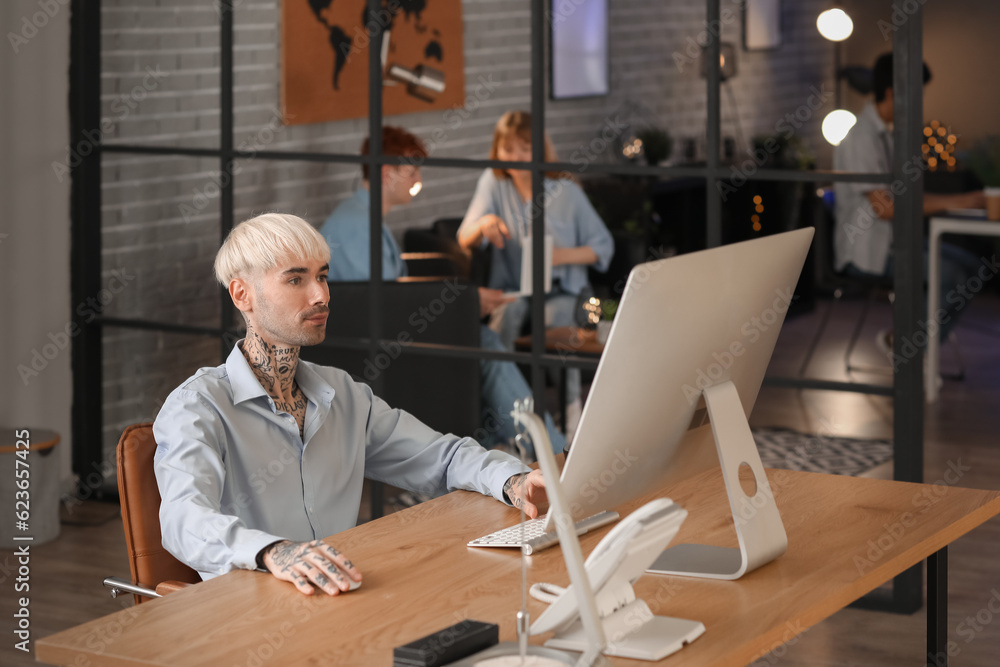 Male programmer working with computer in office at night