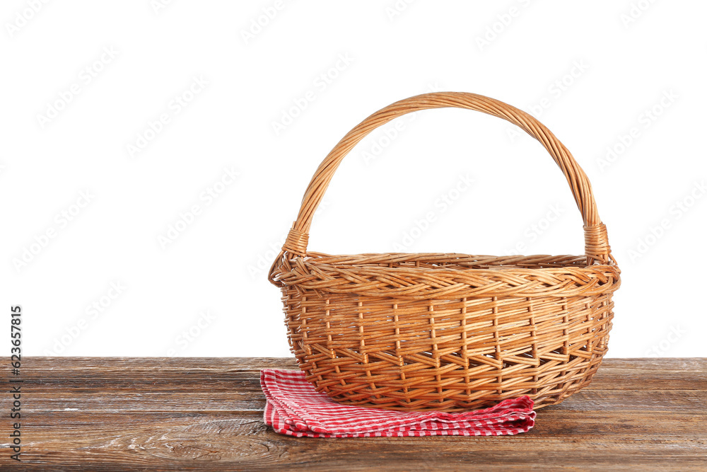 Wicker picnic basket and napkin on wooden table against white background