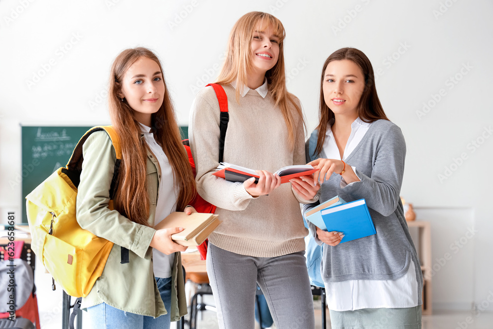 Female students with books in classroom