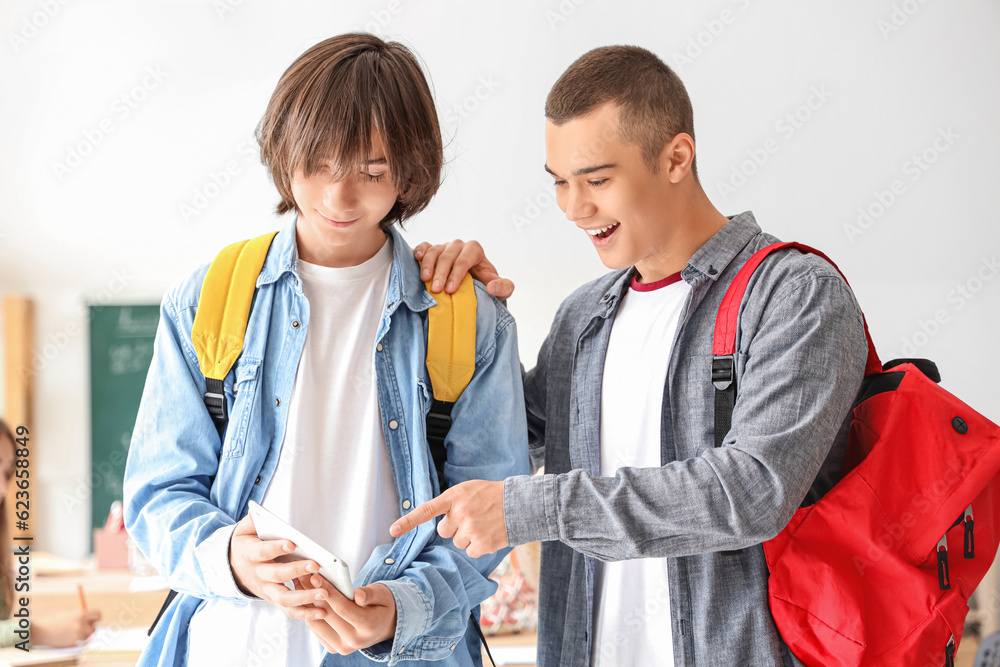 Male students with tablet computer in classroom