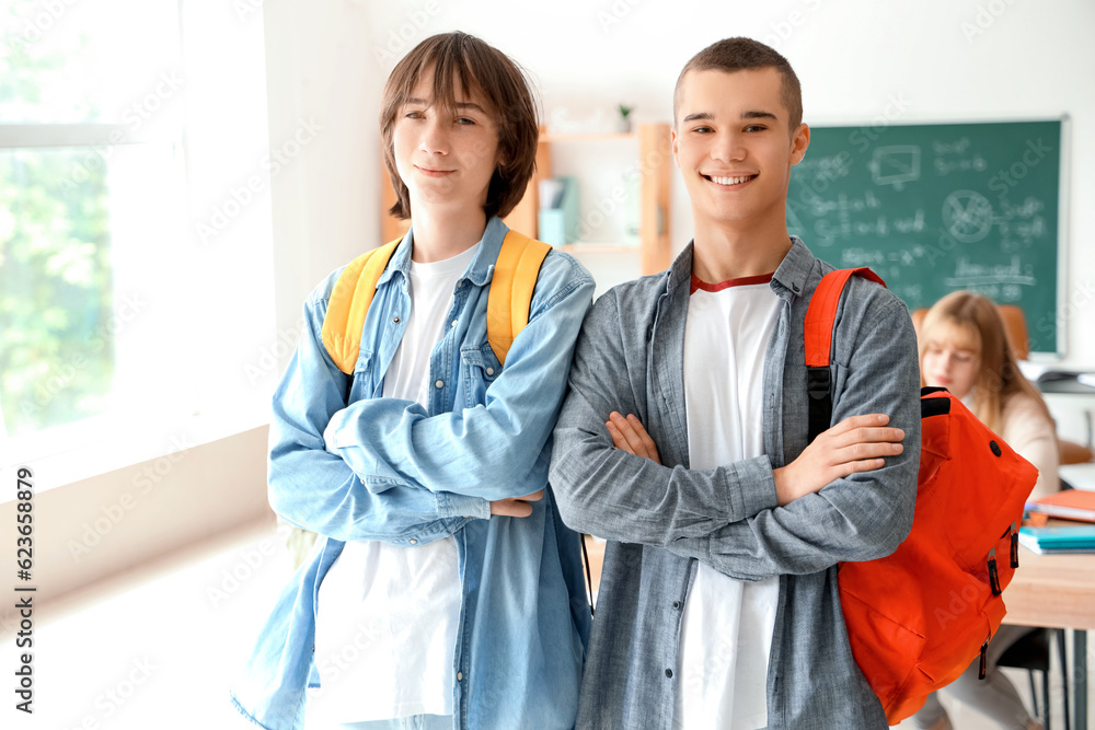 Male students with backpacks in classroom