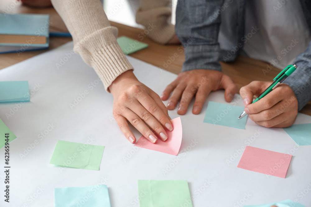 Teenage students performing task at table in classroom, closeup