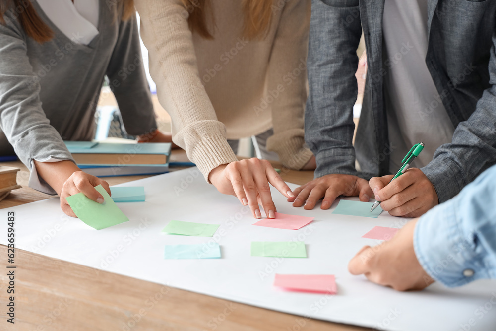 Group of teenage students performing task at table in classroom, closeup