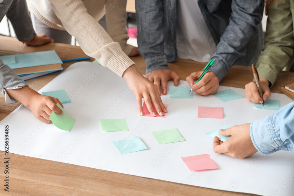 Group of teenage students performing task at table in classroom, closeup