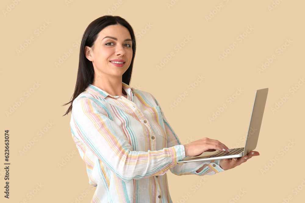 Female programmer working with laptop on beige background