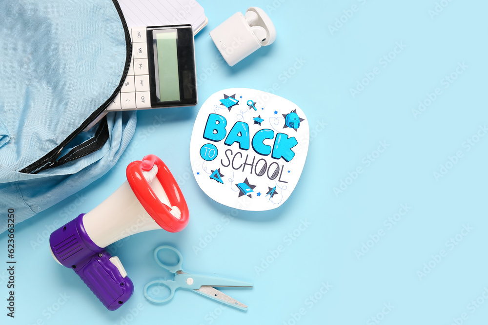 Backpack, stationery, earphones, megaphone and sheet with text BACK TO SCHOOL on blue background