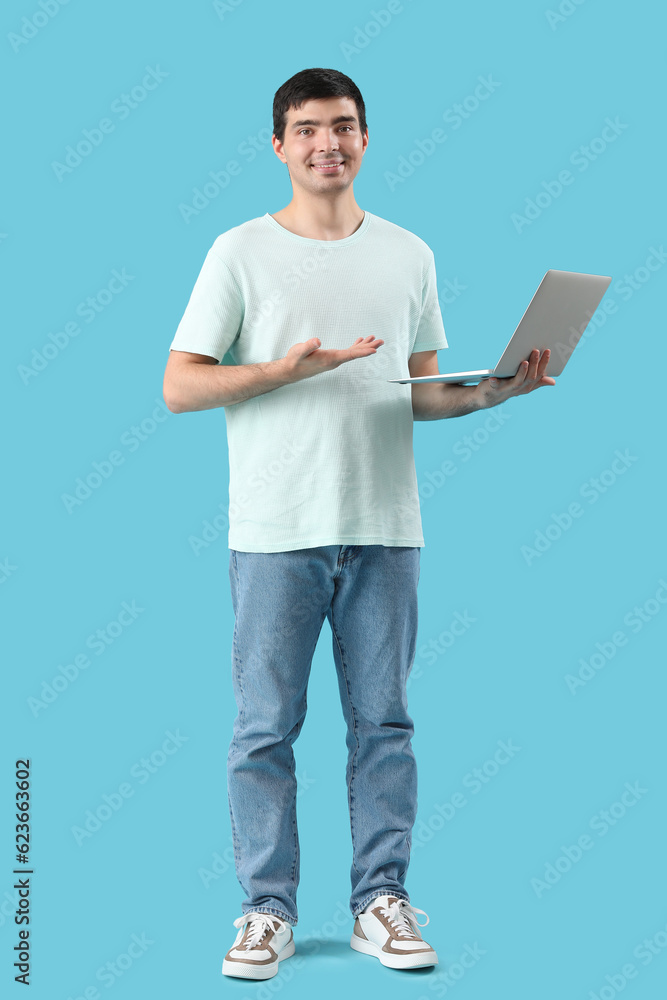 Male programmer with laptop on blue background