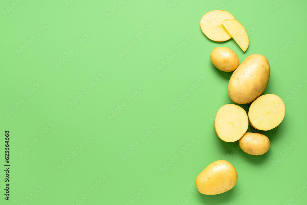 Frame made of raw potatoes on green background