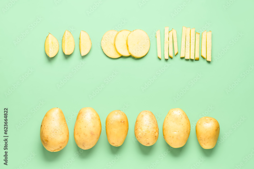 Frame made of raw potatoes on green background