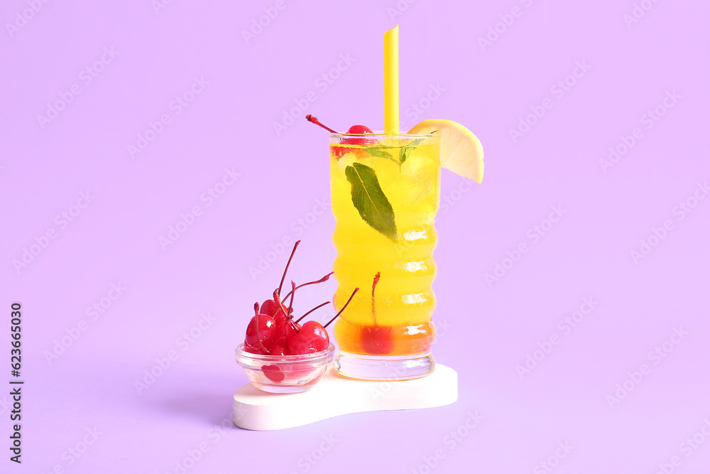 Bowl of tasty maraschino cherries and glass with cold cocktail on lilac background