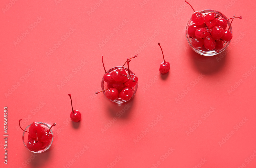 Bowls of tasty maraschino cherries on red background