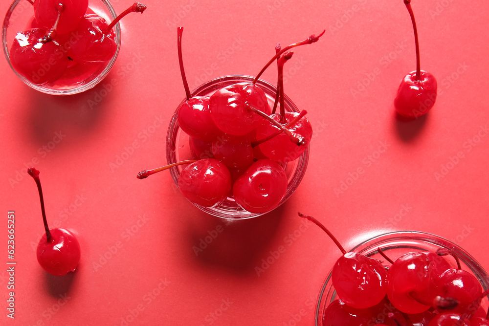 Bowls of tasty maraschino cherries on red background