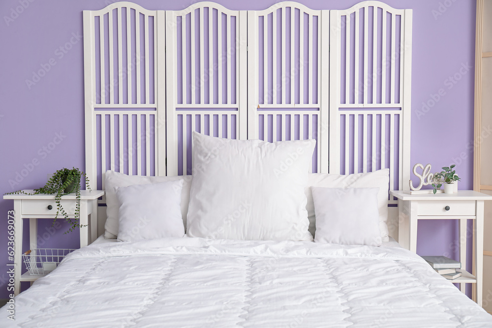 Comfortable bed with white pillows in interior of stylish bedroom