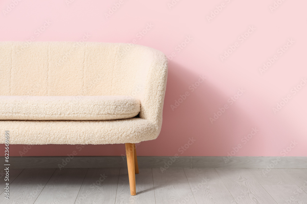 Cozy white sofa near pink wall