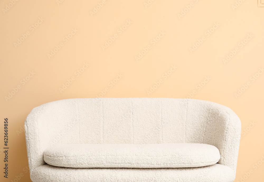 Cozy white sofa near beige wall