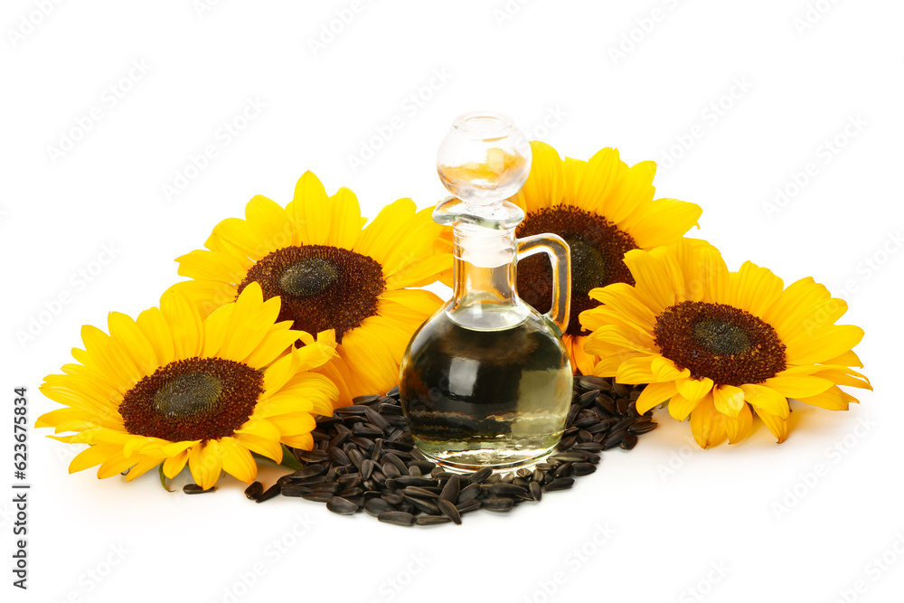 Sunflowers, seeds and decanter with oil on white background