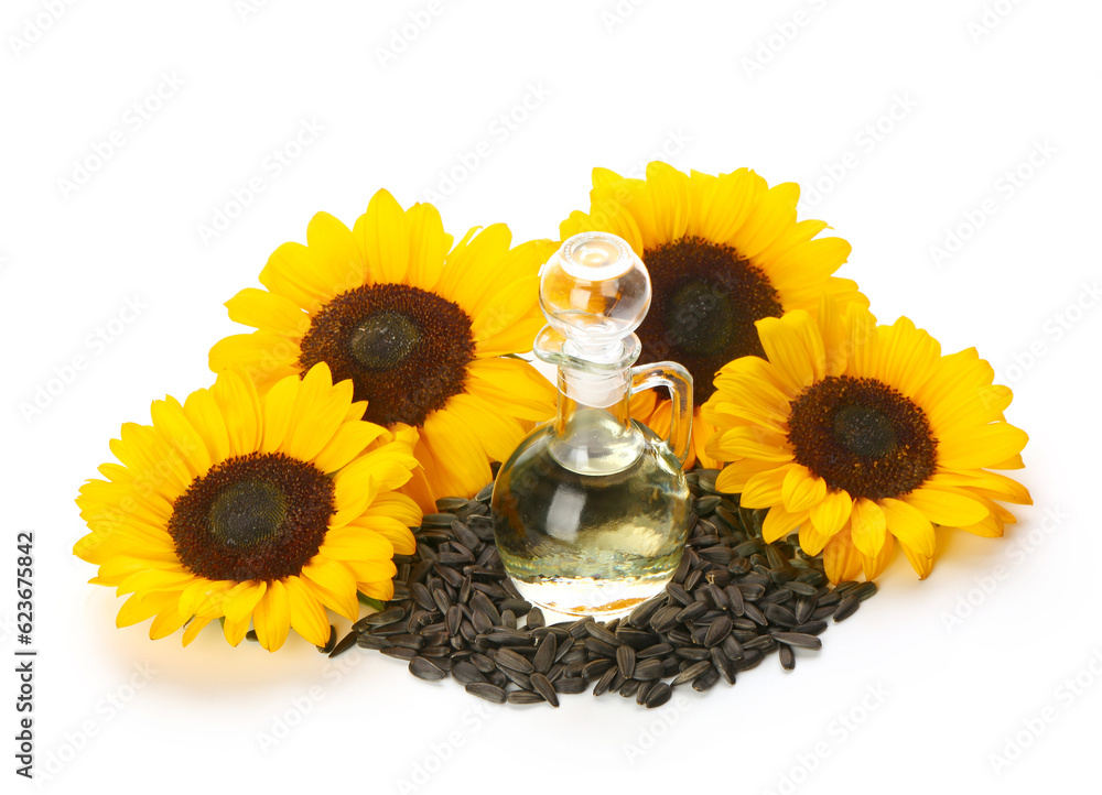 Sunflowers, seeds and decanter with oil on white background