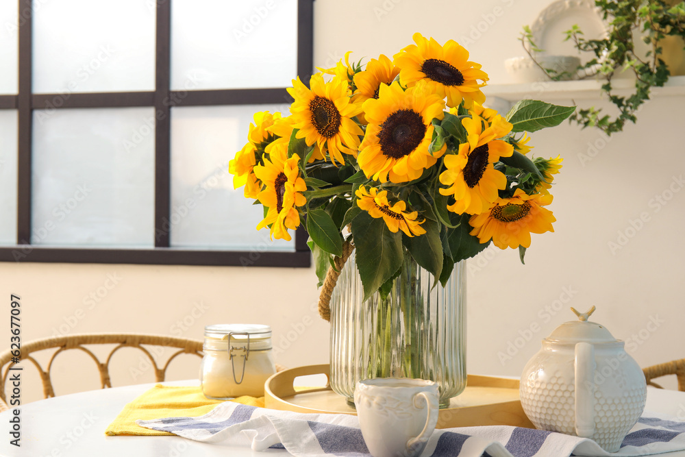 Vase with beautiful sunflowers on dining table, closeup