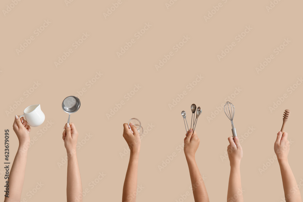 Female hands with baking utensils on beige background