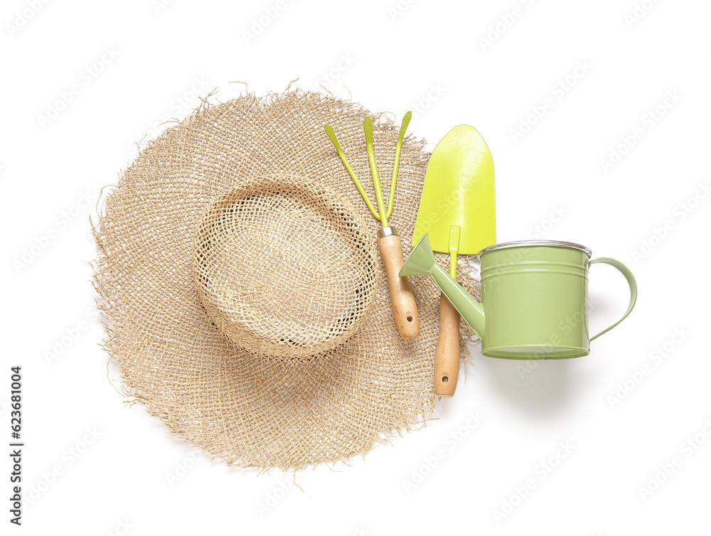 Straw hat and different gardening tools on white background