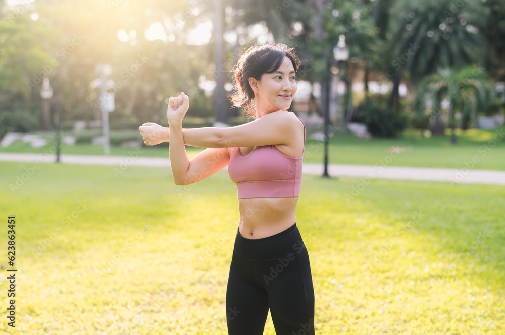 wellness and healthy lifestyle portrait 30s Asian woman in pink sportswear. preparing and stretching