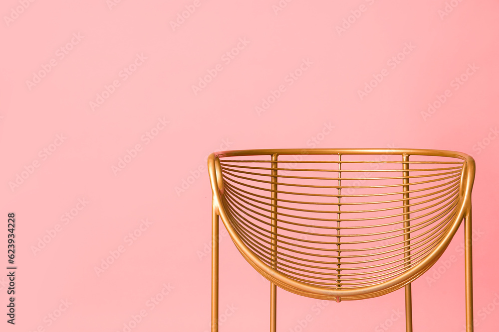 Golden armchair on pink background