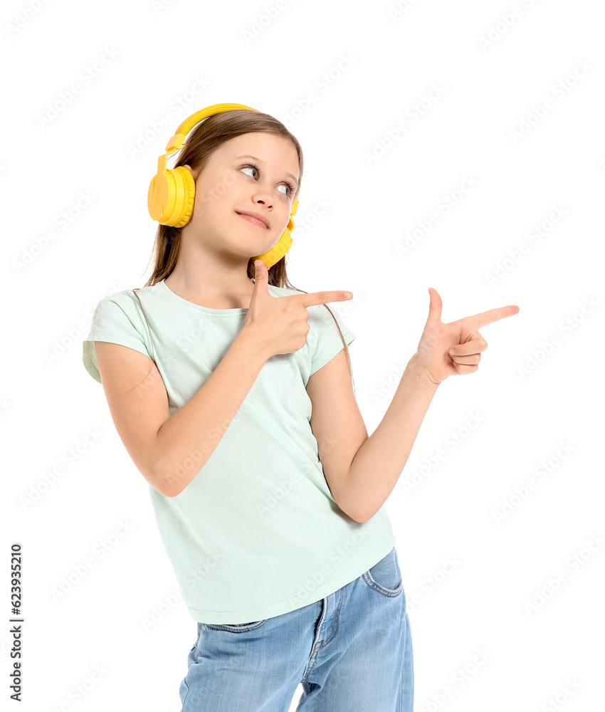 Little girl in headphones pointing at something on white background