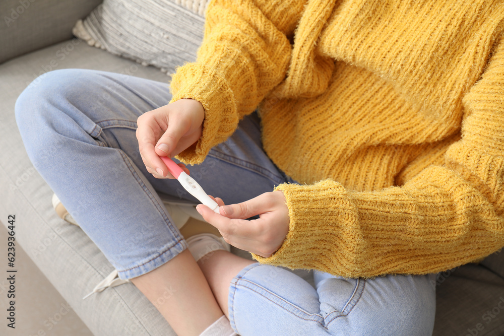 Young woman with pregnancy test at home, closeup