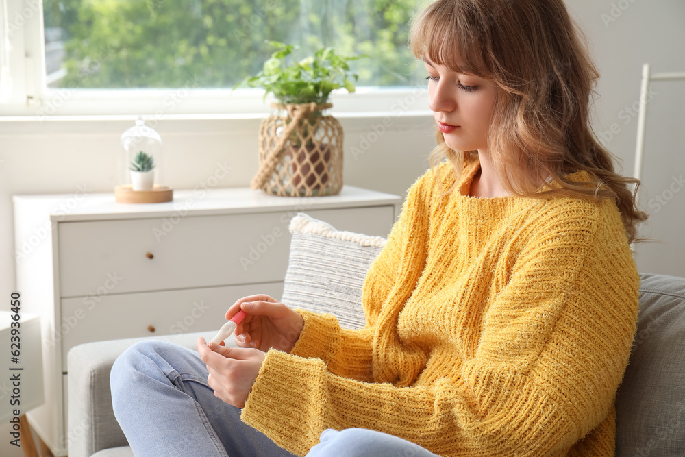 Young woman with pregnancy test at home