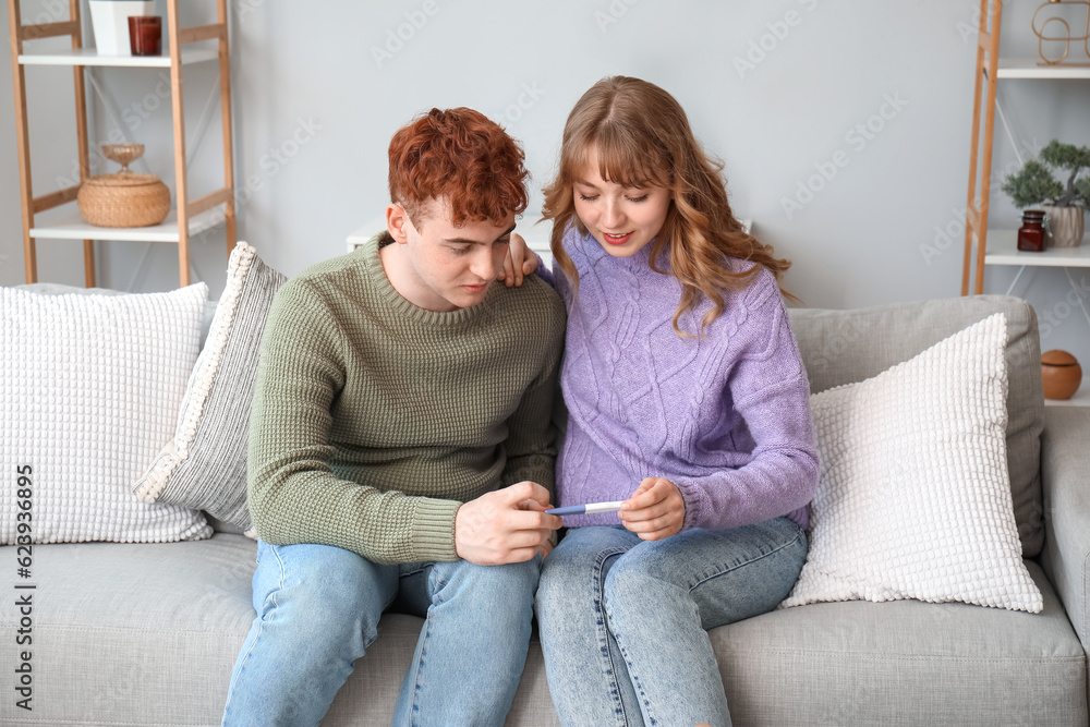 Happy young couple with pregnancy test at home