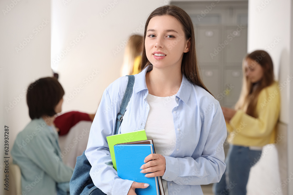 Teenage girl with copybooks at school