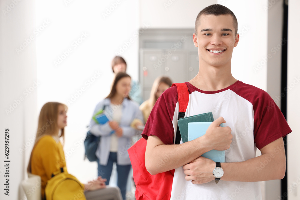 Teenage boy with books at school