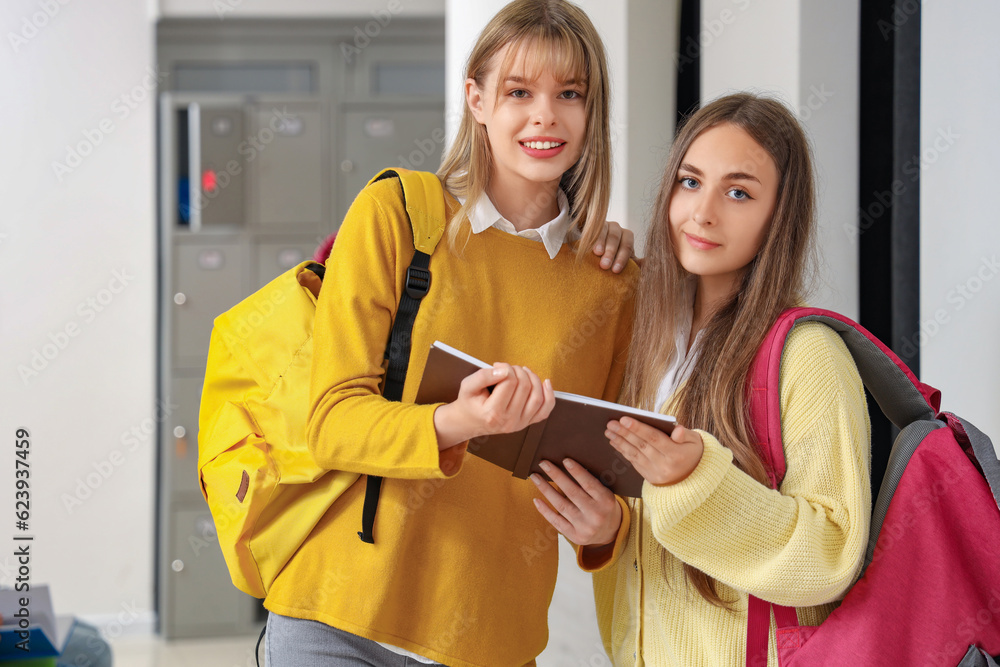 Teenage girls reading book at school