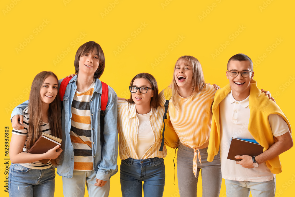 Group of teenage students on yellow background