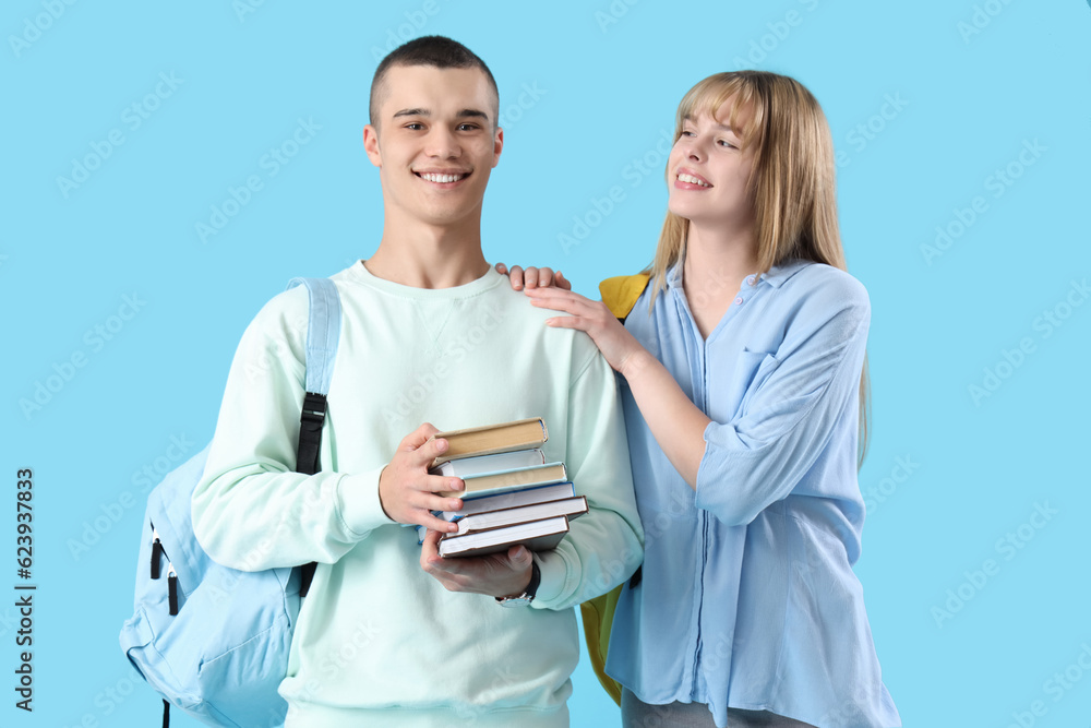 Couple of teenage students on blue background