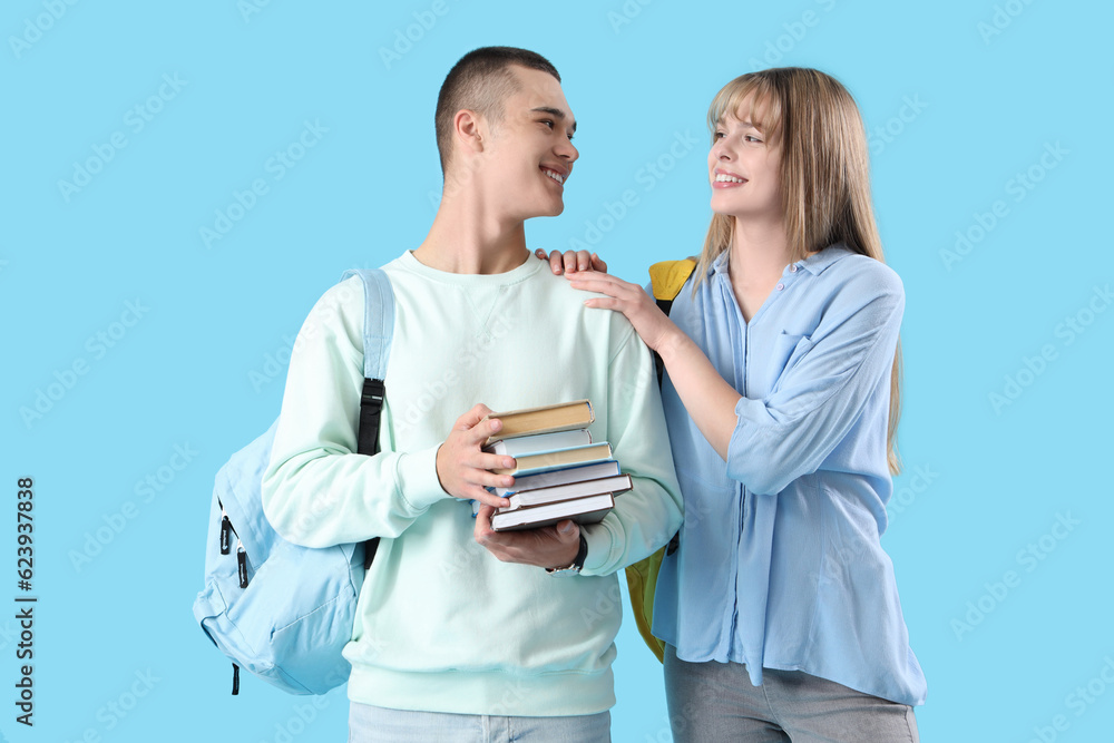 Couple of teenage students on blue background