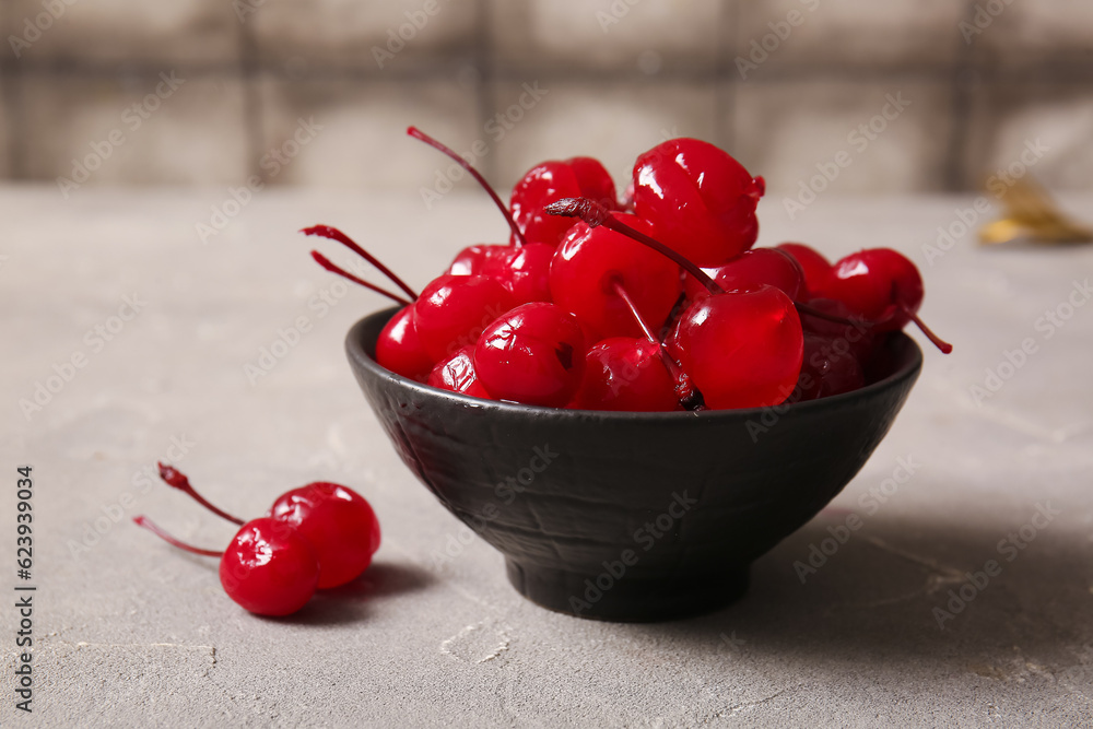 Bowl of tasty maraschino cherries on table