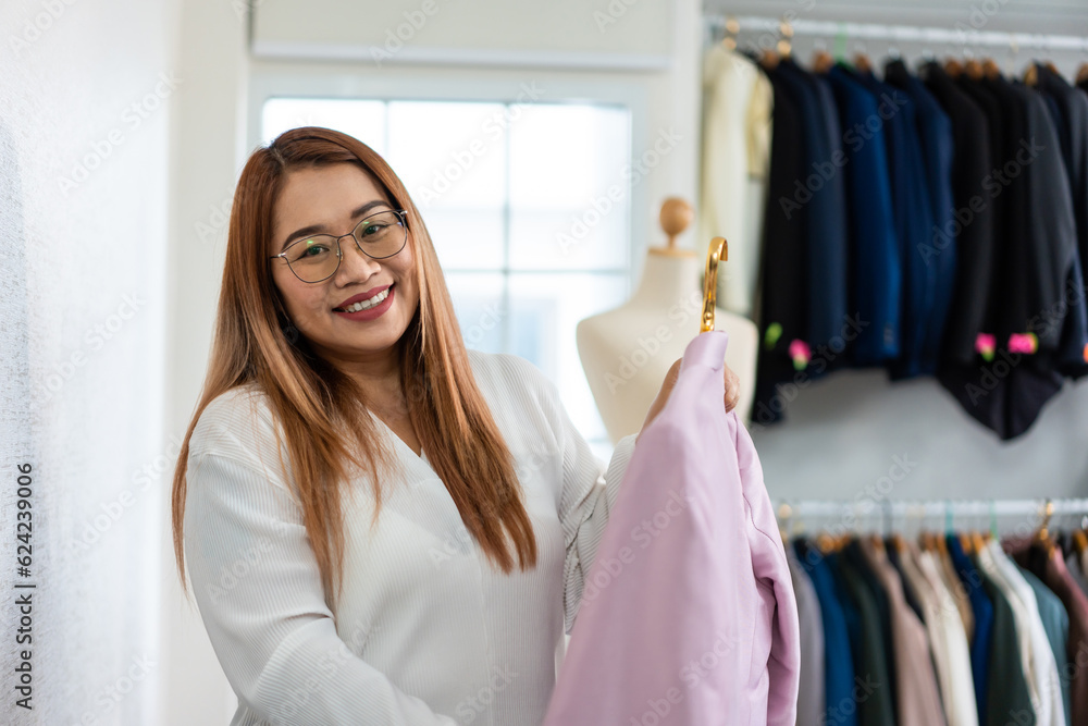 Portrait of Asian women fashion designer working in tailoring atelier. 