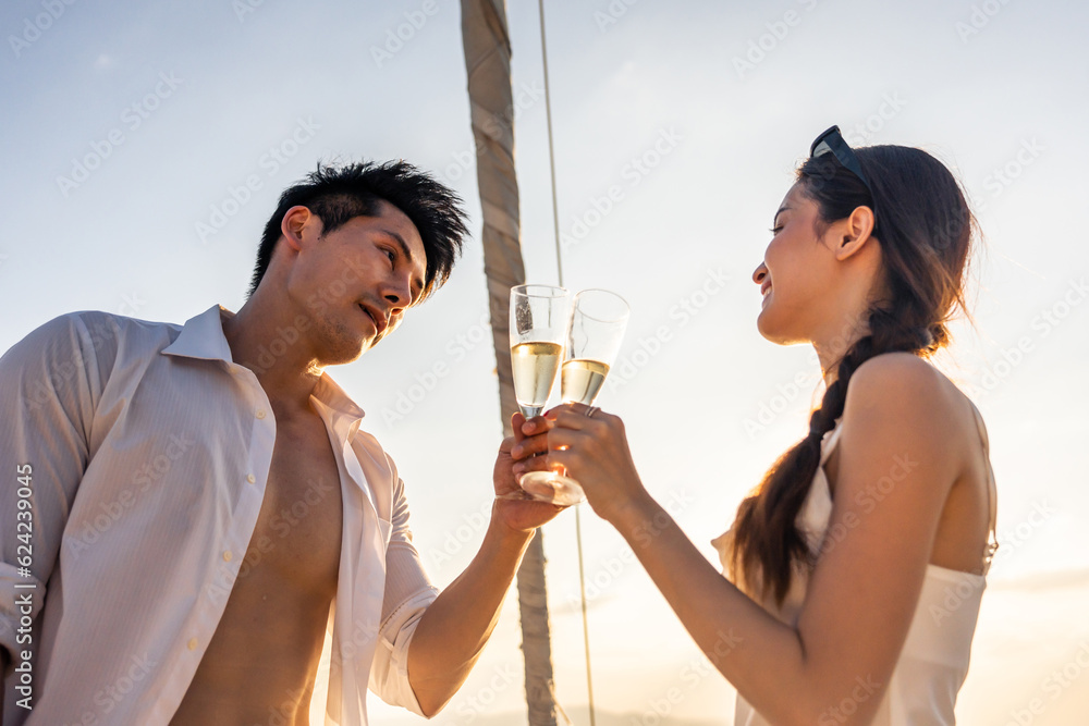 Caucasian young couple drinking champagne while having party in yacht. 