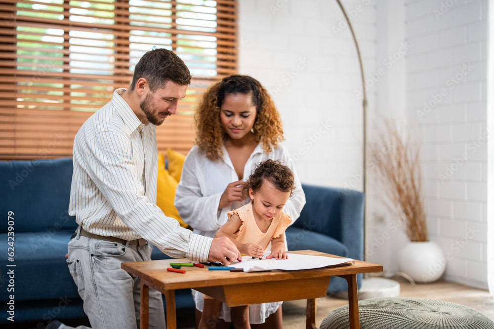 Caucasian family painting on paper with parents indoors in house. 